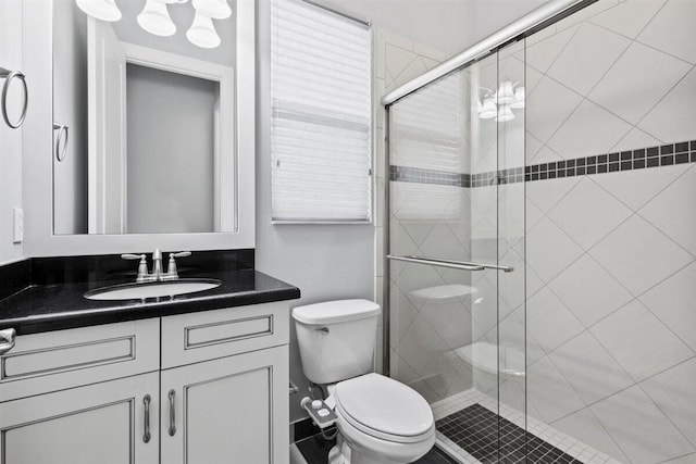 full bathroom with vanity, a shower stall, and toilet