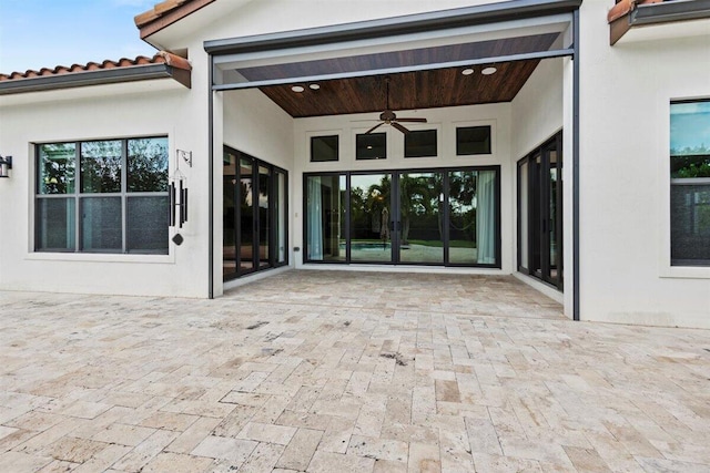 property entrance with ceiling fan, a patio, and stucco siding