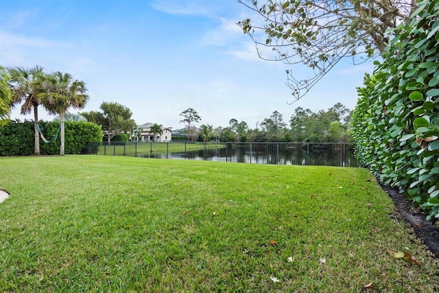 view of yard with a water view and fence