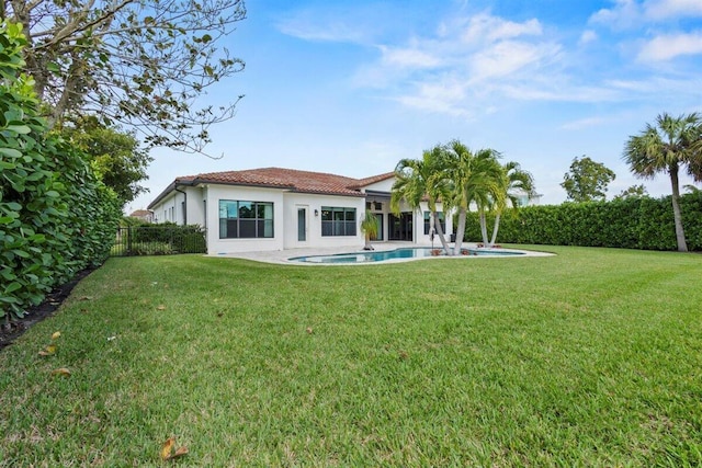 back of property featuring a fenced in pool, stucco siding, a lawn, fence, and a tiled roof