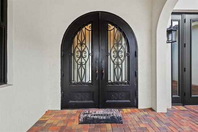 doorway to property featuring french doors and stucco siding