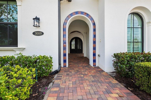 doorway to property featuring french doors and stucco siding