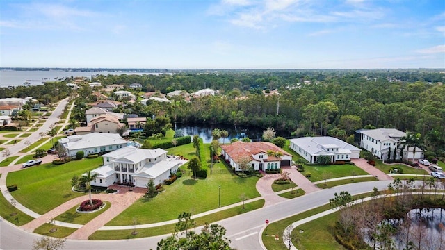 aerial view featuring a residential view, a water view, and a view of trees