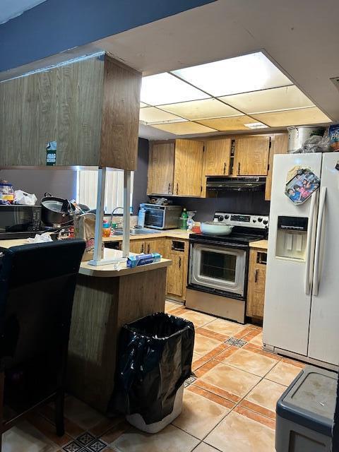 kitchen featuring white fridge with ice dispenser, range hood, sink, stainless steel electric range oven, and light tile patterned flooring