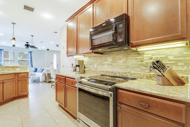 kitchen with light tile patterned floors, tasteful backsplash, light stone countertops, and electric range