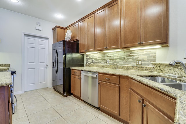 kitchen with sink, black fridge with ice dispenser, light stone counters, and dishwasher