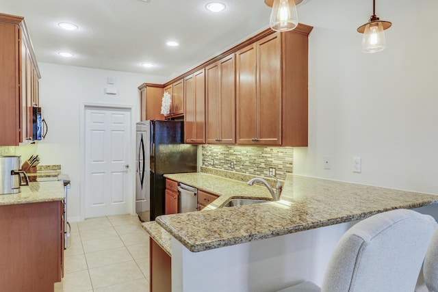 kitchen with decorative light fixtures, sink, light stone countertops, and kitchen peninsula