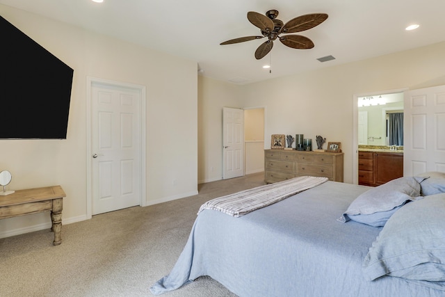 carpeted bedroom featuring ceiling fan and ensuite bath