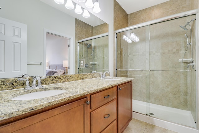 bathroom with a shower with shower door, vanity, and tile patterned floors