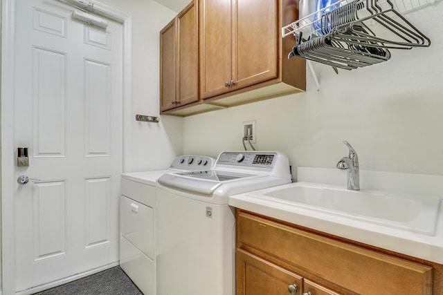 washroom featuring sink, independent washer and dryer, and cabinets