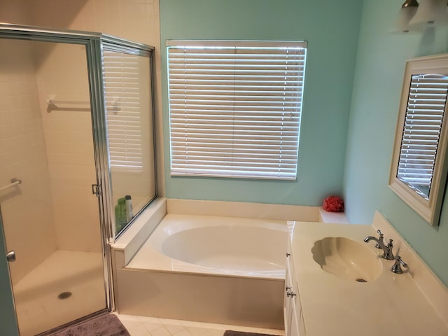 bathroom featuring plus walk in shower, vanity, and a wealth of natural light