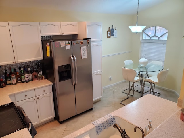 kitchen featuring white cabinets, hanging light fixtures, light tile patterned floors, and stainless steel fridge with ice dispenser