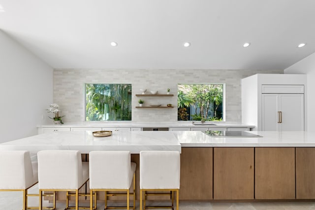 kitchen featuring light stone countertops, open shelves, backsplash, and recessed lighting