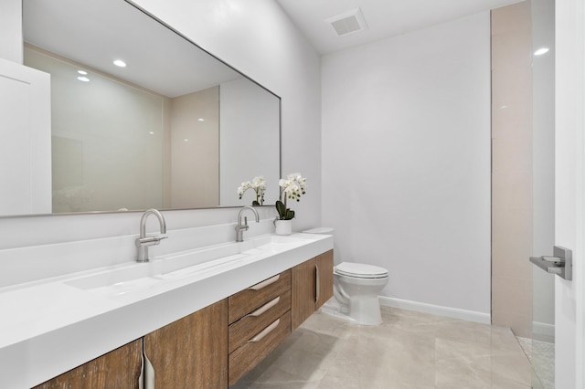 bathroom featuring toilet, double vanity, a sink, and visible vents