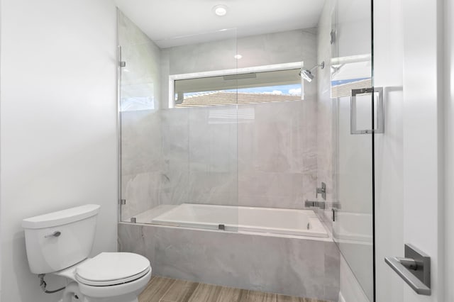 bathroom with combined bath / shower with glass door, toilet, and wood finished floors