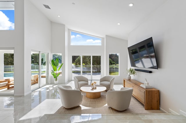 living room featuring high vaulted ceiling, recessed lighting, visible vents, baseboards, and marble finish floor