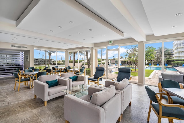 living room featuring stone tile floors and visible vents