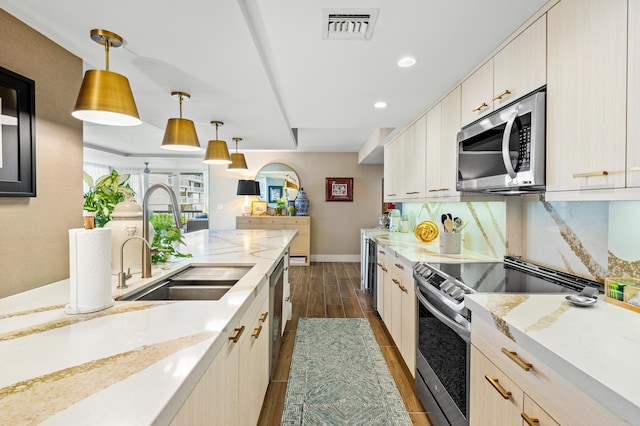 kitchen with dark wood-style floors, pendant lighting, stainless steel appliances, visible vents, and a sink