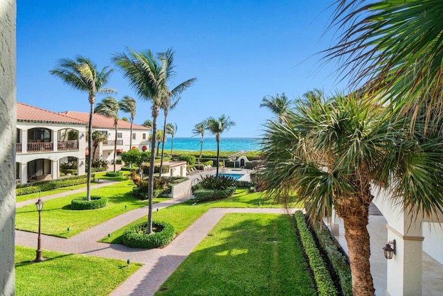 view of property's community featuring a water view and a lawn