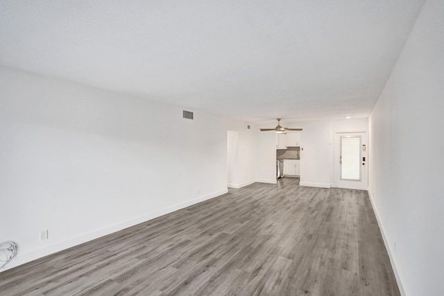 unfurnished living room featuring visible vents, ceiling fan, light wood-style flooring, and baseboards