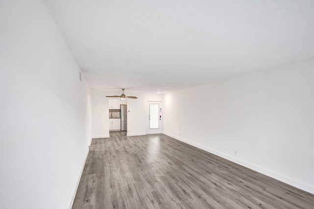 unfurnished living room featuring light wood-style floors, ceiling fan, and baseboards