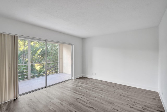 spare room featuring a textured ceiling and wood finished floors