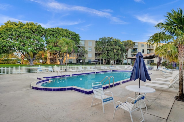 community pool featuring fence and a patio