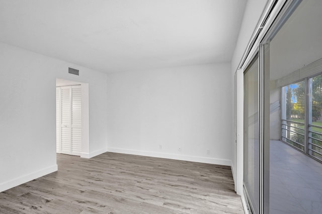 empty room featuring visible vents, baseboards, and wood finished floors