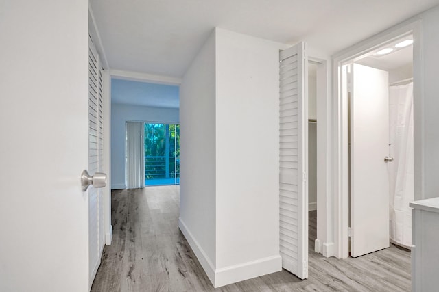 corridor with wood finished floors and baseboards