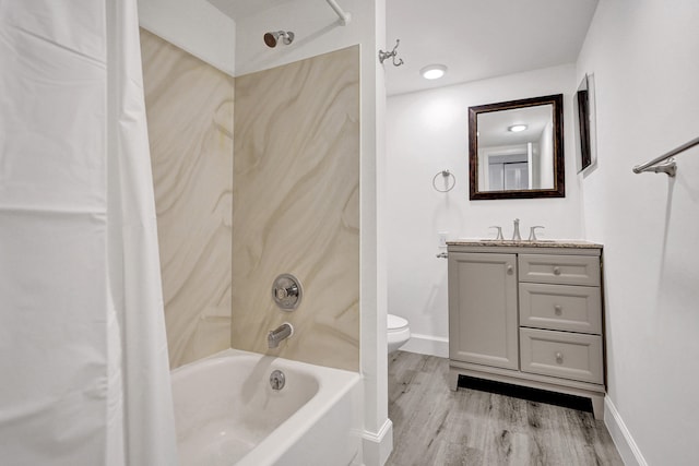 bathroom with baseboards, toilet, shower / tub combo with curtain, wood finished floors, and vanity