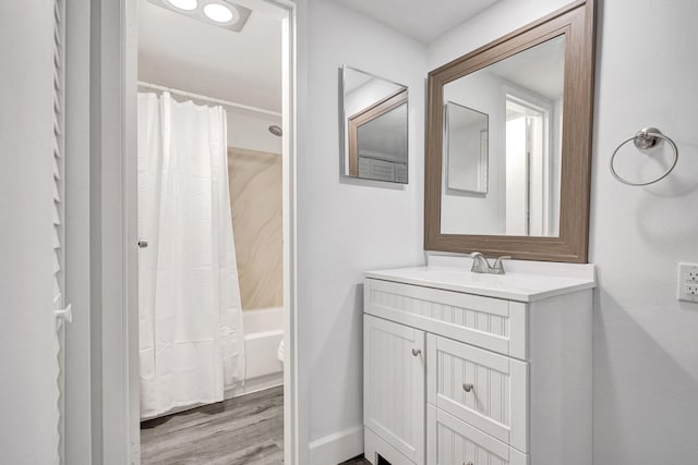 bathroom with shower / bath combination with curtain, wood finished floors, and vanity