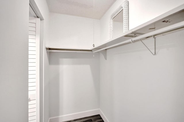 walk in closet with wood finished floors