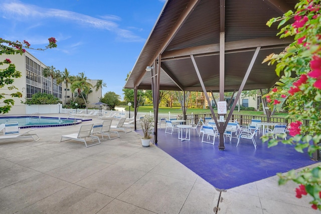 view of patio / terrace with a community pool and fence