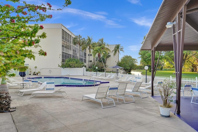 community pool featuring a patio and fence