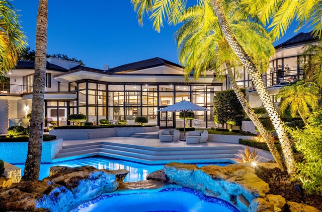 outdoor pool with a sunroom and a patio area