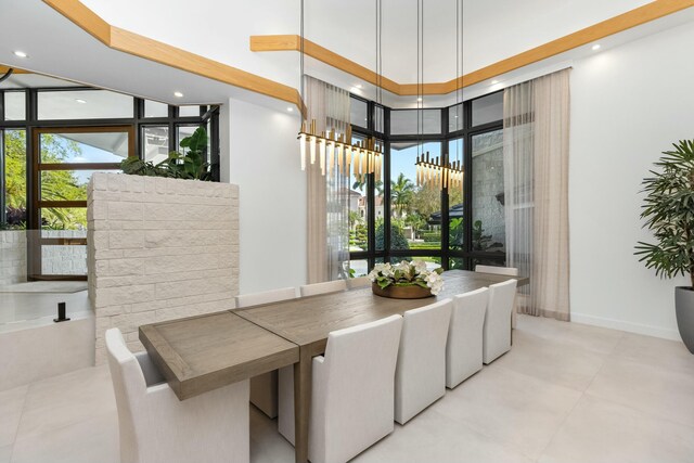 dining area featuring recessed lighting, expansive windows, a towering ceiling, and baseboards