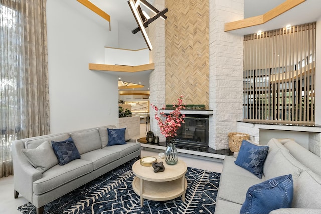 living room featuring a fireplace and a towering ceiling