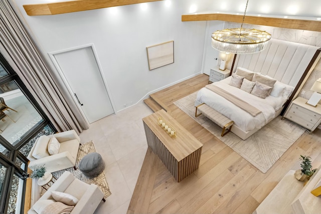 bedroom featuring light wood-type flooring and an inviting chandelier