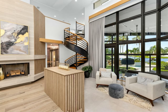 living area with a large fireplace, a high ceiling, and stairs