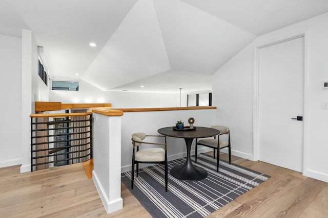 dining room with recessed lighting, vaulted ceiling, and wood finished floors