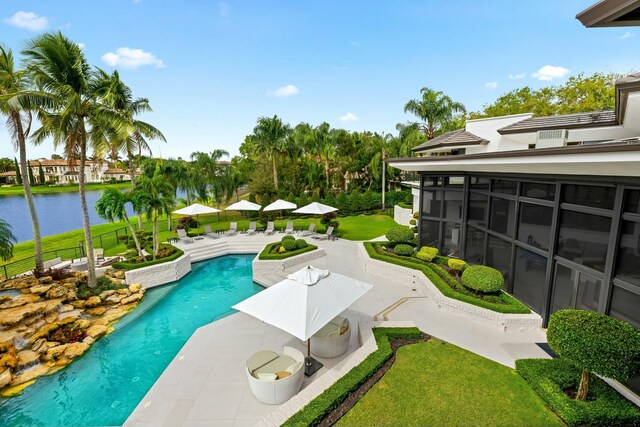outdoor pool featuring a water view, a yard, a patio, and a sunroom