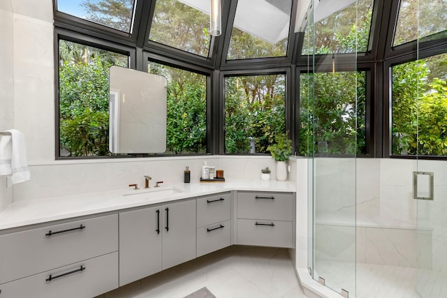 bathroom with marble finish floor, a marble finish shower, and vanity