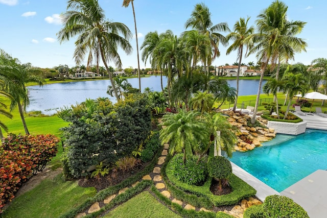 outdoor pool featuring a water view and a lawn