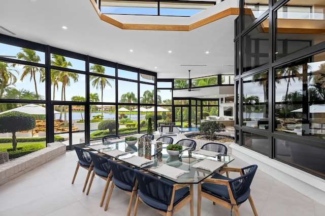 sunroom featuring tile patterned floors, a wall of windows, recessed lighting, and a healthy amount of sunlight