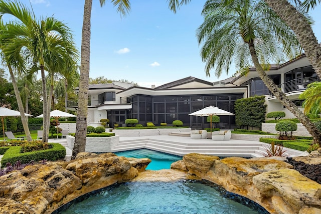pool with a jacuzzi, a patio area, and a sunroom