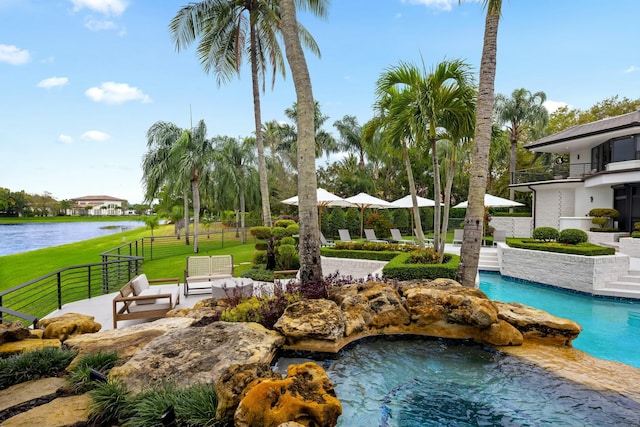 pool featuring a yard, fence, a patio, and a water view