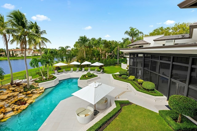 outdoor pool with a yard, a patio, a water view, and a sunroom