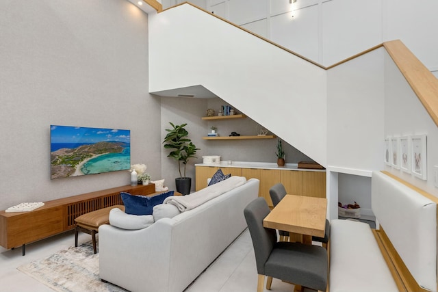 living room with light tile patterned floors and a high ceiling