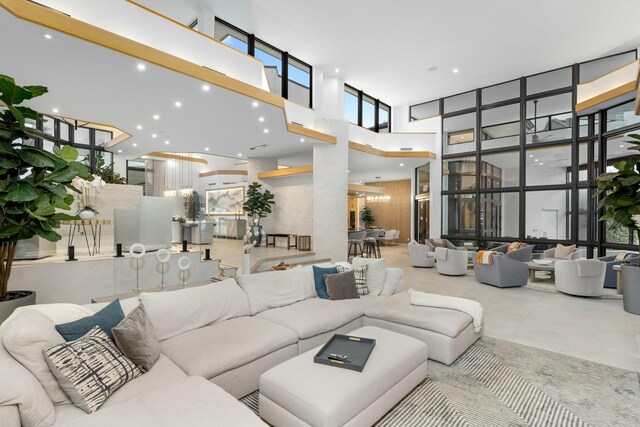 living room with recessed lighting, floor to ceiling windows, and a towering ceiling