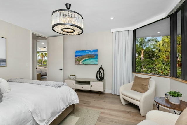 bedroom with light wood finished floors and a notable chandelier